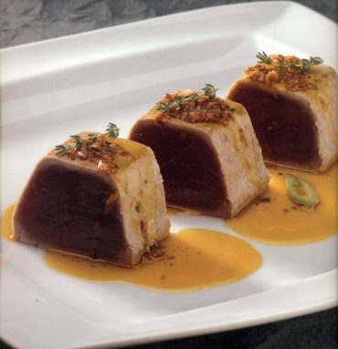 Plato con dados de atún en adobo recién fritos