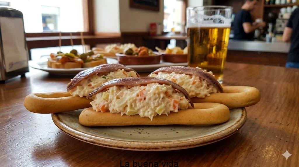 Bol rústico lleno de ensaladilla rusa cremosa coronada con tiras de pimiento rojo y huevo picado sobre una mesa de madera.